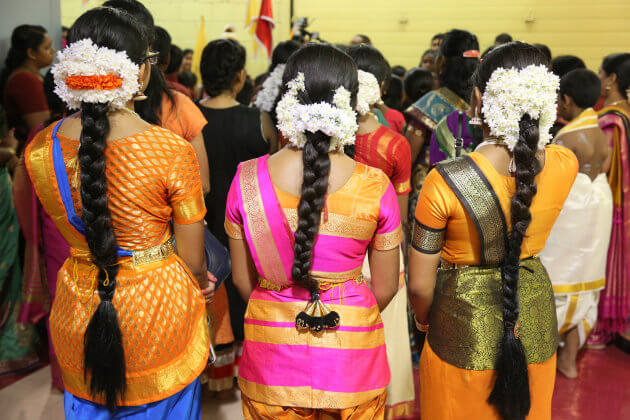 Tamil Hindu children listen to prayers after performing a Bharatnatyam dance during the Nambiyaandaar Nambi Ustavam Thiruvizha pooja at a Hindu Temple in Ontario, Canada, on 19 July 2017. This pooja is part of the 15 day long festival that honours Lord Ganesh which culminates with the extravagant chariot procession. During this Puja an idol of Lord Ganesh is paraded around the temple as prayers are performed. (Photo by Creative Touch Imaging Ltd./NurPhoto via Getty Images)